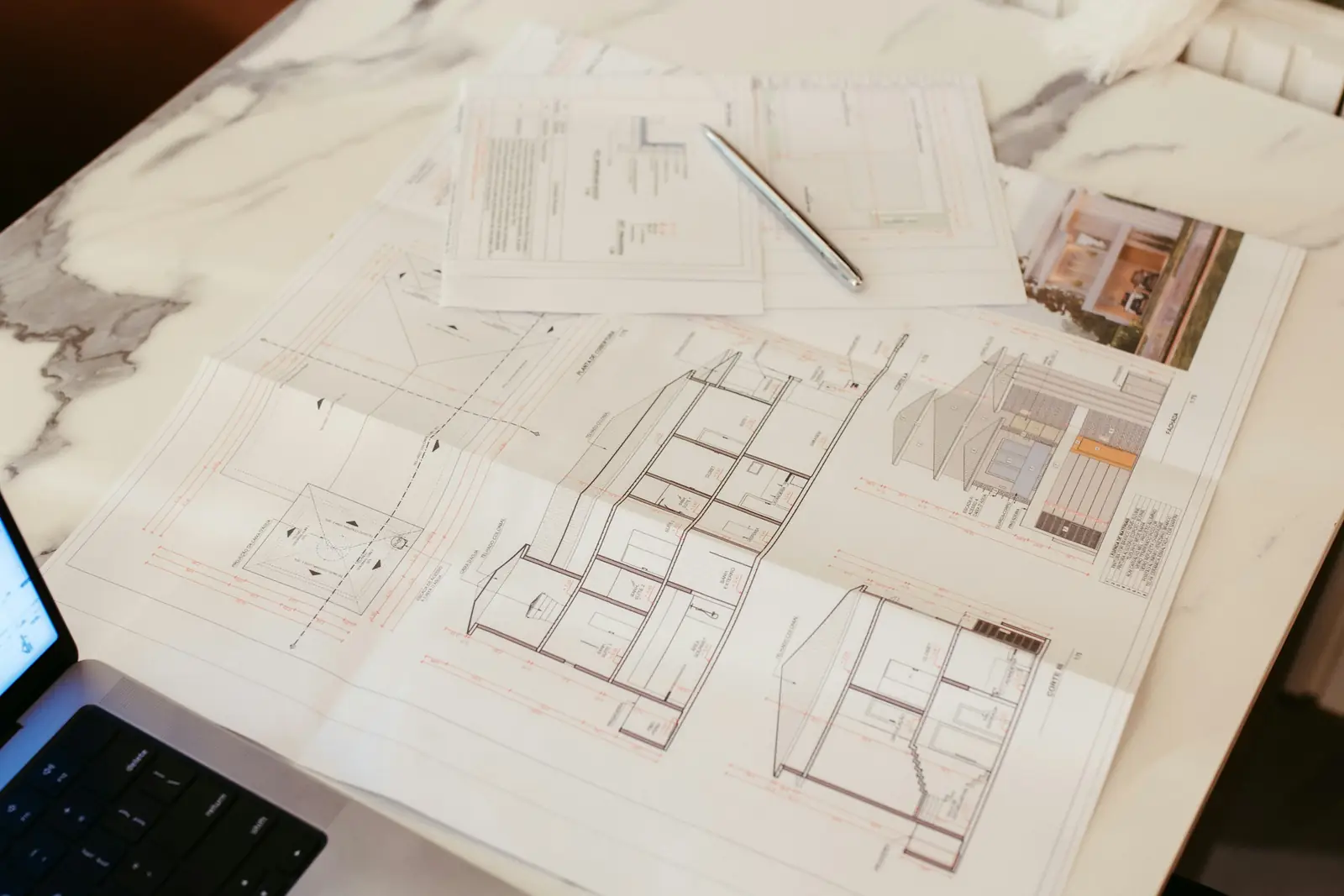 Planos y un notebook sobre un escritorio